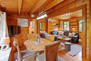 a dining room and living room in a log cabin at Ortheide 67 in Böddenstedt