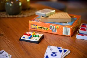a wooden table with a toy item and playing cards at Ortheide 67 in Böddenstedt +42 photos