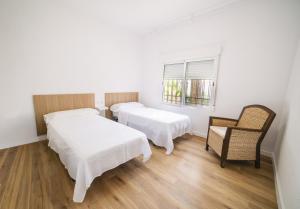 a room with two beds and a chair and a window at Villa Marie in Benicarló +20 photos
