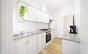 a white kitchen with white cabinets and a sink at Villa Marie in Benicarló