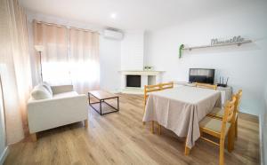 a living room with a table and a couch and a television at Villa Marie in Benicarló