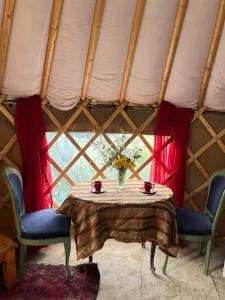 a table in a yurt with two chairs and a window at Fabulous Glamping Yurt in Bantry