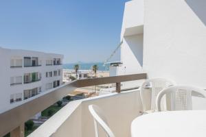 a balcony with white chairs and a view of a building at Valdelagrana en Primera Linea in El Puerto de Santa María