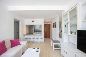 a living room with a white couch and a kitchen at Valdelagrana en Primera Linea in El Puerto de Santa María