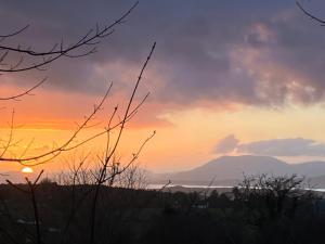 a sunset with a mountain in the background at Fabulous Glamping Yurt in Bantry