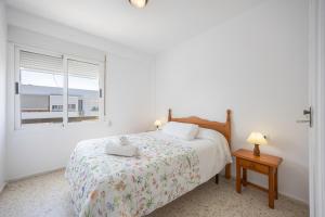 a white bedroom with a bed and a window at Valdelagrana en Primera Linea in El Puerto de Santa María +33 photos