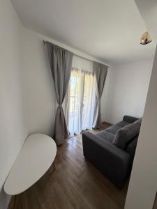 a living room with a couch and a window at ThasosGoldenStay in Skala Potamias