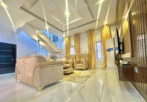 a living room with couches and a staircase at Serene 5 Bedroom Duplex With Exclusive Compound in Iseri