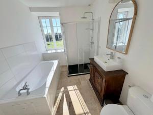 a white bathroom with a tub and a sink at Longère près des plages, 11 pers 5 chambres! in Trégunc +18 photos