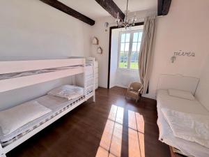 a bedroom with two bunk beds and a window at Longère près des plages, 11 pers 5 chambres! in Trégunc