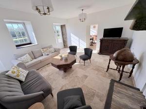 a living room with a couch and a tv at Longère près des plages, 11 pers 5 chambres! in Trégunc