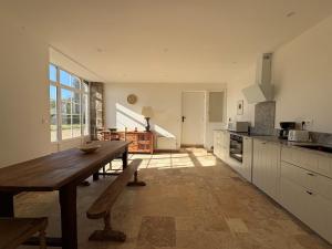 a large kitchen with a wooden table and a wooden table sidx sidx sidx at Longère près des plages, 11 pers 5 chambres! in Trégunc