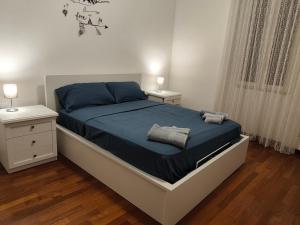 a bedroom with a bed with blue sheets and two night stands at La Perla di Sulmona in Sulmona