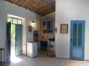 a kitchen with a white refrigerator and a blue door at Antica Verdureria in Terme di Castel Doria