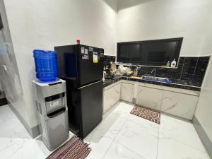 a kitchen with a black refrigerator and a sink at Urban Canopy City Forest Staycation in Tigbawan