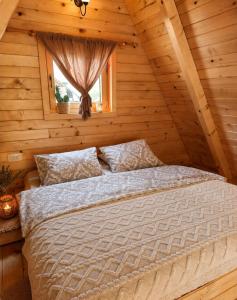 a bedroom with a bed in a log cabin at Holiday Home Veruša in Podgorica