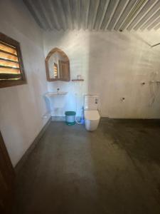a bathroom with a white toilet in a room at Peanut Farm Cabanas -Surf in Panama