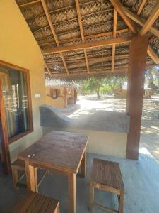 a room with a table and a bench and a roof at Peanut Farm Cabanas -Surf in Panama