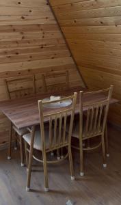 a wooden table and chairs in a cabin at Tau Saty in Saty