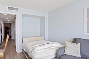 a bedroom with a bed and a couch at Bay Watch Resort 1735 - Direct Oceanfront Balcony with Pools and Lazy River in Myrtle Beach +24 photos