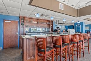 a bar with a row of brown bar stools at Bay Watch Resort 1735 - Direct Oceanfront Balcony with Pools and Lazy River in Myrtle Beach