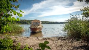 un barco sentado en el agua en un lago en Ferienwohnung mit Seeblick en Rheinsberg