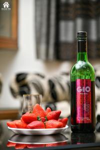 a bottle of alcohol next to a plate of strawberries at CHOCOLATE VILLA Mahabaleshwar in Mahabaleshwar