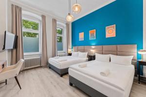 a bedroom with two beds and a blue wall at primeflats - Apartments Genter Berlin-Wedding in Berlin