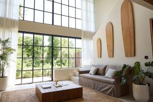 a living room with a couch and a large window at The Young Villas Tropical Villas in Seseh in Canggu