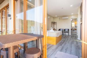 a room with a bed and a table and chairs at Sofia - Summer Coastal Suites in Bacnotan