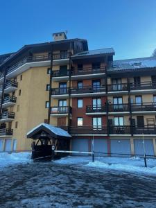 a large apartment building with snow in front of it at Studio de montagne - résidence le saphir in Puy-Saint-Vincent