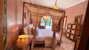 a bedroom with a canopy bed with a window at Villa Amazonika By La Siredrah in Segraga
