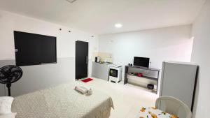 a white room with a bed and a tv at Villa Marçal in São Mateus