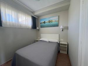 a small bedroom with a bed and a window at Apartamentos Los Jazmines in Torremolinos