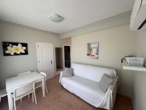 a living room with a white couch and a table at Apartamentos Los Jazmines in Torremolinos