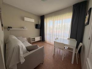 a bedroom with a bed and a table and a desk at Apartamentos Los Jazmines in Torremolinos
