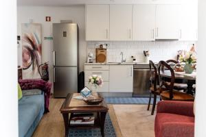 eine Küche mit Sofa, Tisch und Kühlschrank in der Unterkunft Casa do Armando in Achadinha