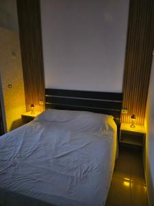 a bedroom with a bed and two night stands with lamps at Hotel Rozafa Velipoje in Baks-Rrjoll +2 photos