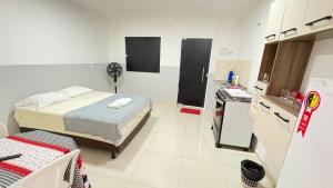 a small room with a bed and a kitchen at Villa Marçal in São Mateus