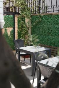 a patio with tables and chairs and a green hedge at SR99 Hotel in Tirana