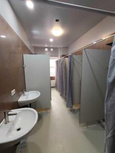 a bathroom with three sinks and a row of stalls at Sitya Hostel München in Munich