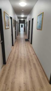 an empty hallway with wood floors and paintings on the walls at Sitya Hostel München in Munich +11 photos