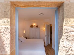 a bedroom with a white bed in a stone wall at El Fort d'Ullastret in Ullastret