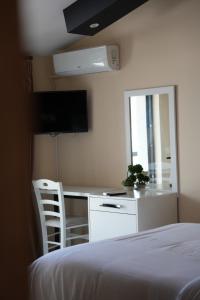 a bedroom with a bed and a desk with a mirror at SR99 Hotel in Tirana