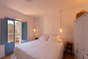 a bedroom with a white bed and a window at El Fort d'Ullastret in Ullastret