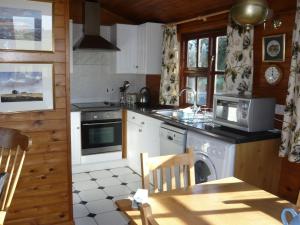 a kitchen with a sink and a stove top oven at Modern Cottage in Romney Marsh near Lake in Brookland