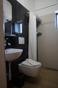 a bathroom with a white toilet and a sink at SR99 Hotel in Tirana +20 photos