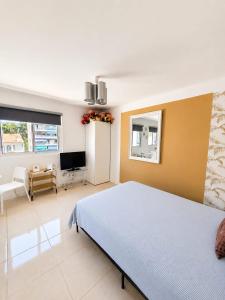 a bedroom with a large bed and a television at Cannes Centre Studio Lumineux et Chic, à 9 Min à Pied du Palais des Festivals et des Plages, Clim in Cannes