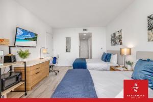a hotel room with a bed and a desk and a tv at Upper Studio Bay Balcony Pool & Shuttle in Hallandale Beach