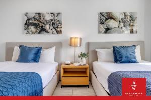 a room with two beds and a nightstand between them at Upper Studio Bay Balcony Pool & Shuttle in Hallandale Beach +39 photos